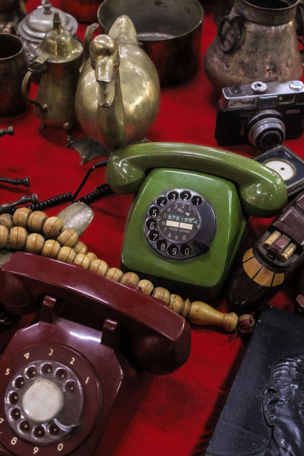 A collection of vintage telephones and brassware